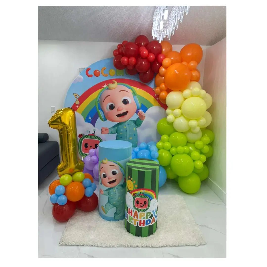 Cocomelon themed first birthday decorations with rainbow balloon garland, backdrop and gold number one balloon in a Miami home.