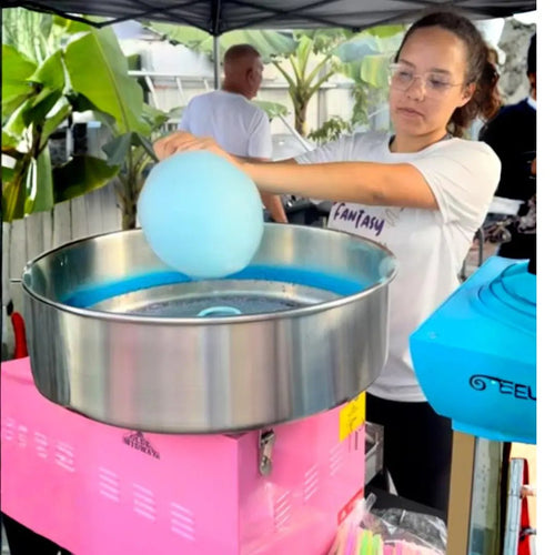 Cotton candy machine rental in Miami: a Fantasy Entertainments attendant spinning fluffy blue cotton candy at an outdoor event.