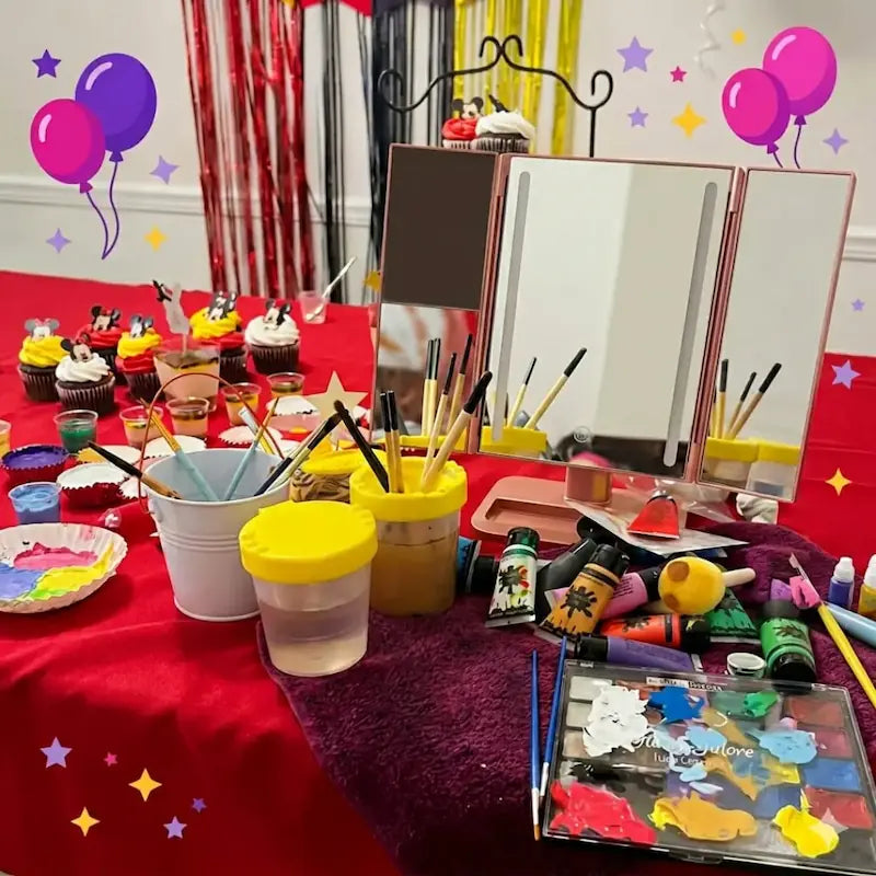 Professional face painting station with tri-fold mirror, brushes and paint palette on a red table, ready for a Miami birthday party.