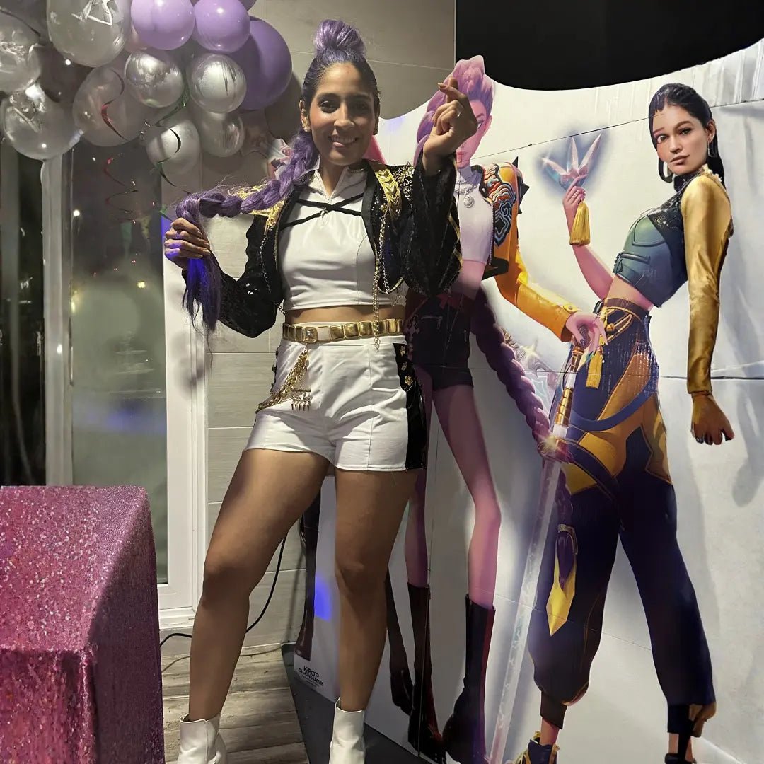 KPop Demon Hunters themed party entertainer dressed as Rumi posing with character cutouts and purple balloon garland in Miami.