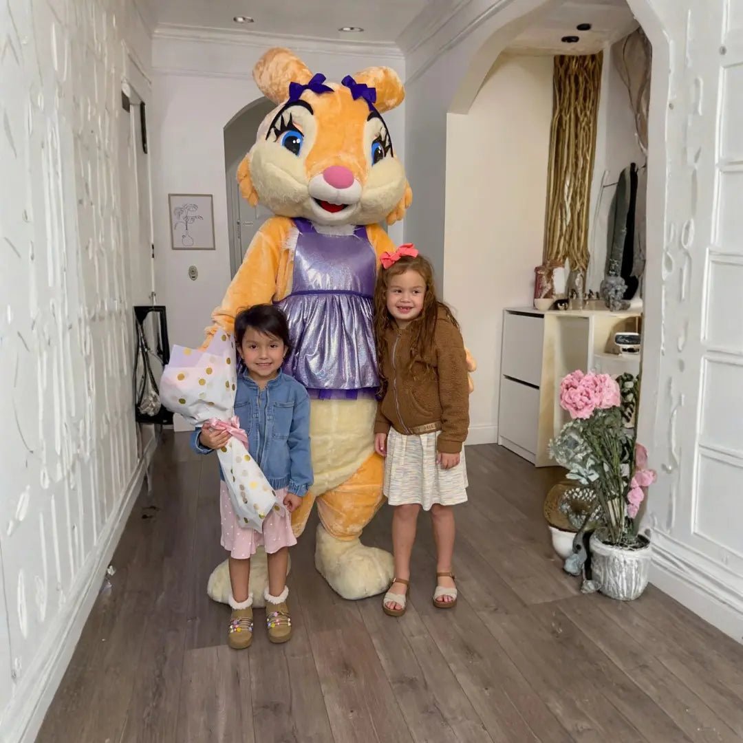 Loli the Bunny posing for a photo with two little girls holding a flower bouquet during a meet and greet at a Miami home.