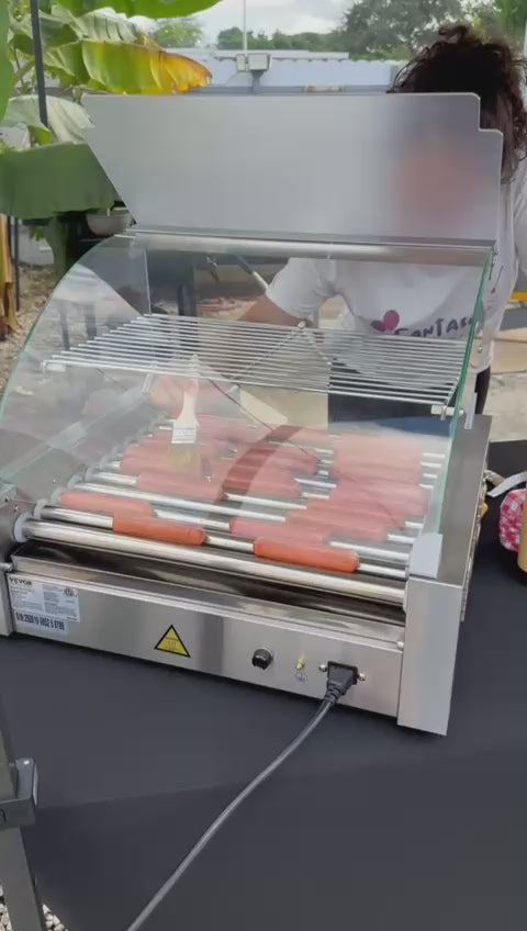 Short video of a Fantasy Entertainments attendant cooking hot dogs on a roller grill station at an outdoor Miami event.