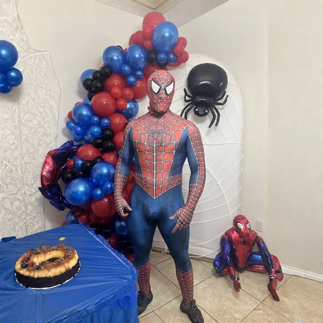 Spider-Man superhero party entertainer posing by a red and blue balloon garland with spider decor at a boy's birthday party in Miami.